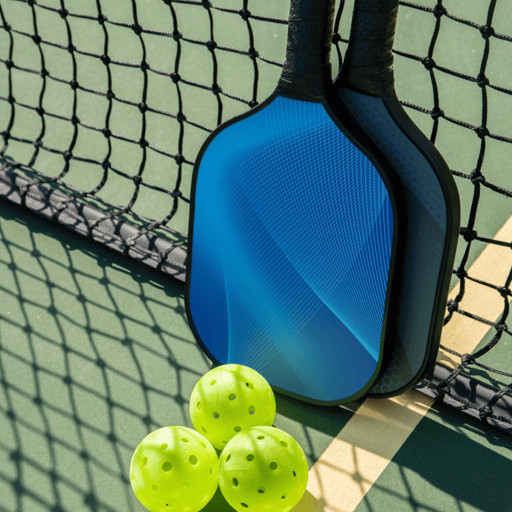 Racket and pickleball on a court.
